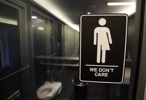 FILE - This Thursday, May 12, 2016, file photo, shows signage outside a restroom at 21c Museum Hotel in Durham, N.C. North Carolina is in a legal battle over a state law that requires transgender people to use the public restroom matching the sex on their birth certificate. Some small business owners already working to make their companies more welcoming to LGBT employees say the massacre at a gay dance club in Orlando, Fla., gives them an impetus to make more changes. In this photo, the Americans with Disabilities Act-compliant bathroom sign was designed by artist Peregrine Honig. (AP Photo/Gerry Broome, File)
